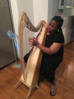 • Andrea Campbell testing out the harp at the National Czech Museum of Music, Prague